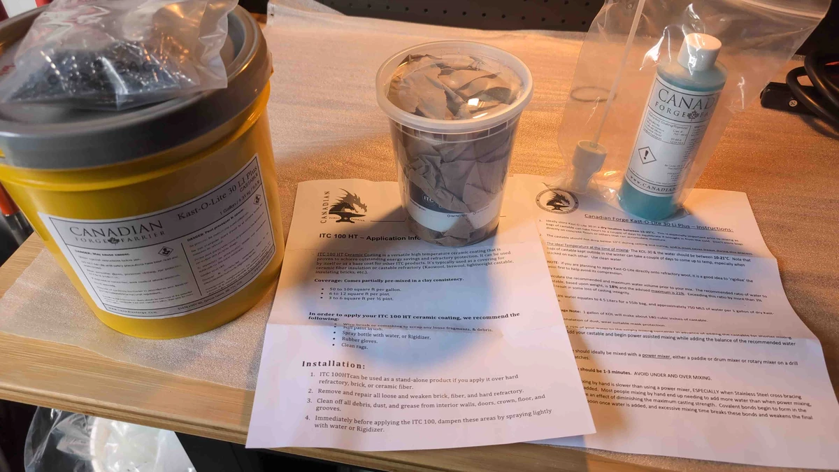 Refractory coating supplies arranged on a workbench.