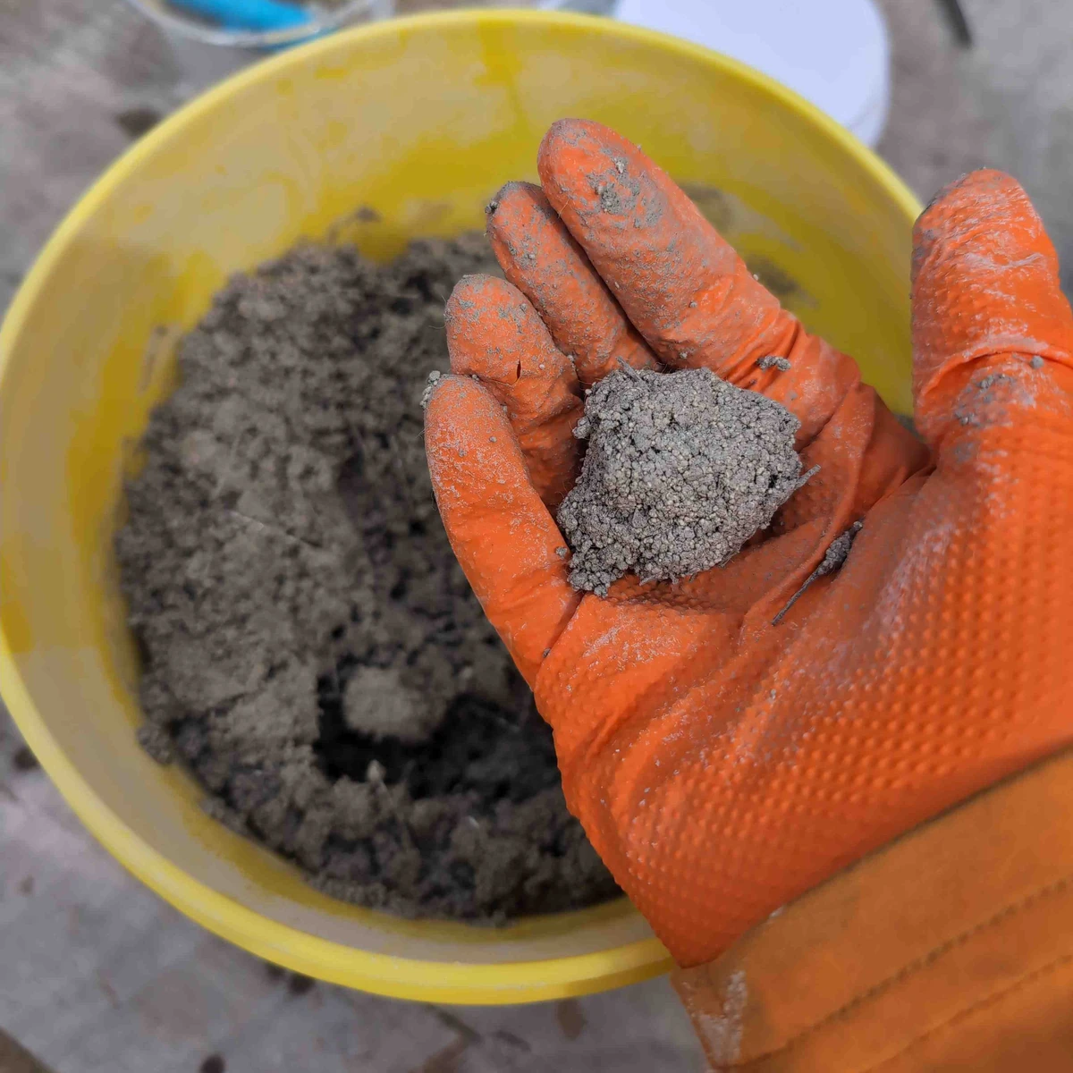 A ball of refractory being held in a hand.